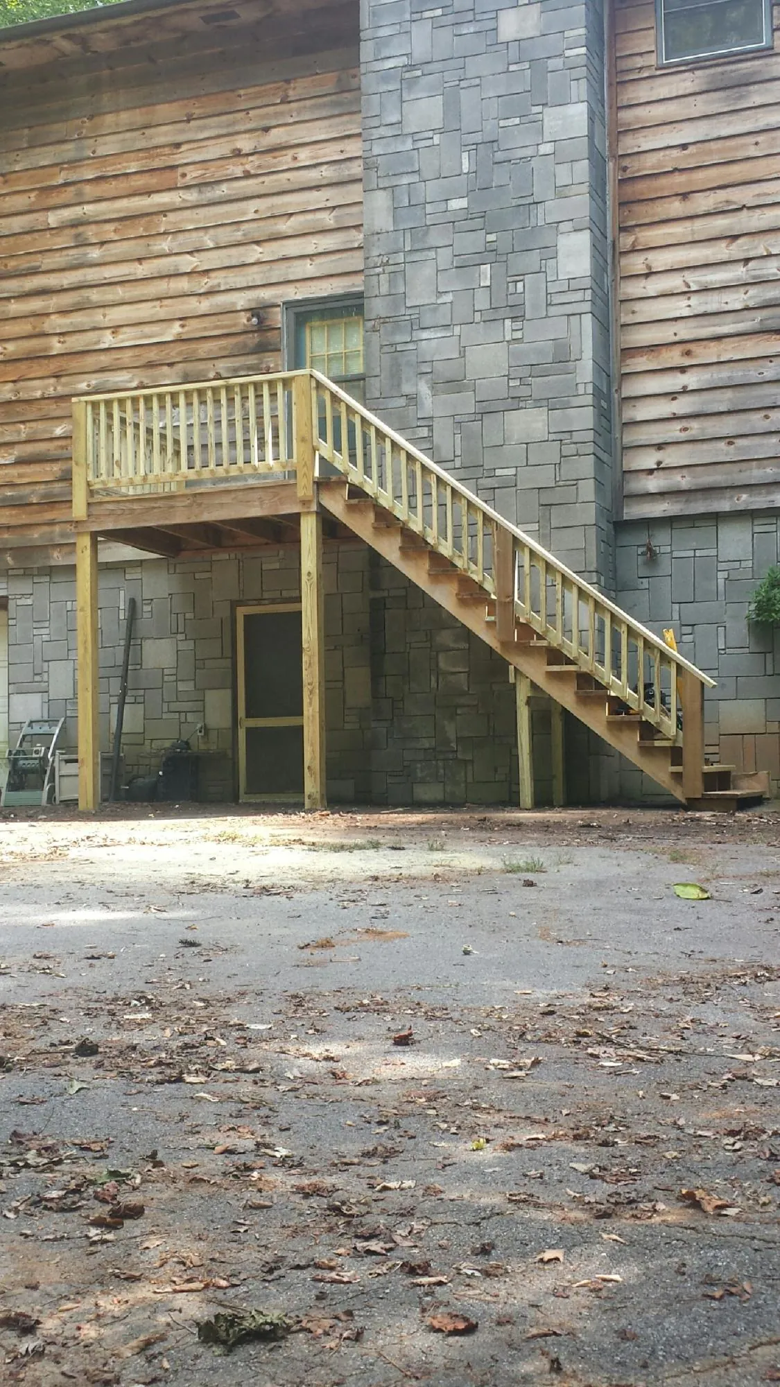 New pressure treated deck and stair landing on a log home in Orange City