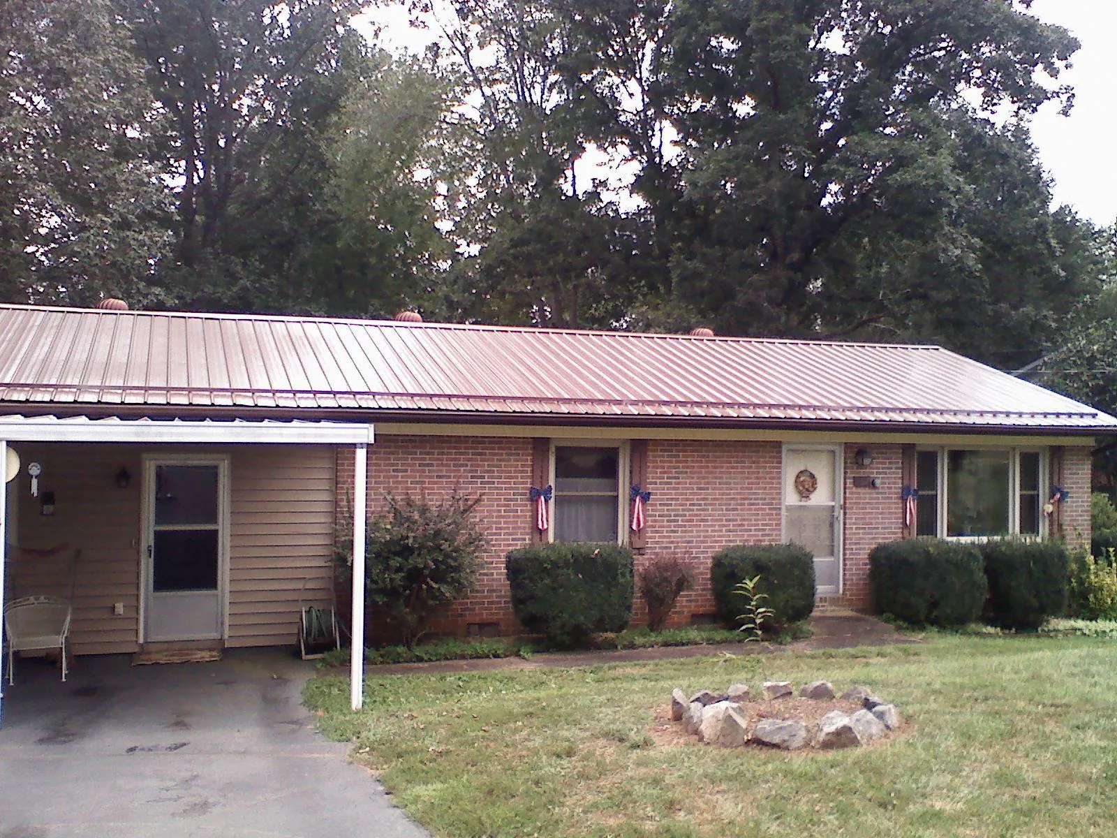 Bronze metal roof and carport on a brick ranch home — Roof Repair work by our crew in Orange City